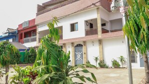A two-story building with a white facade, a balcony on the upper floor, and a gated entrance. - Residence Appartements Luxueux - Angre - Abidjan (Abidjan)