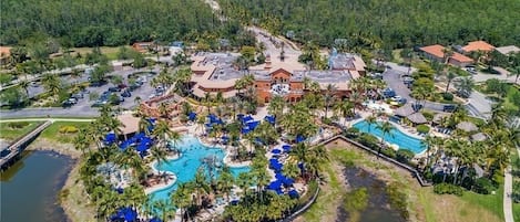 Ein Resort mit mehreren Swimmingpools, Palmen und einem zentralen Gebäude.