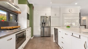 Enjoy cooking in this well-equipped kitchen with a stainless steel refrigerator, oven, and dishwasher.