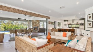 Relax in this inviting living area with a comfortable seating area, stone fireplace, and modern kitchen.