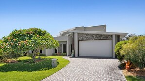 A modern two-story house with a paved driveway leading to a garage.