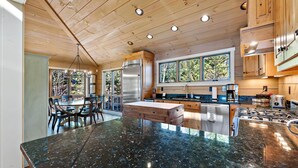 Una cocina moderna con armarios de madera, encimera de granito y un amplio ventanal que proporciona luz natural.