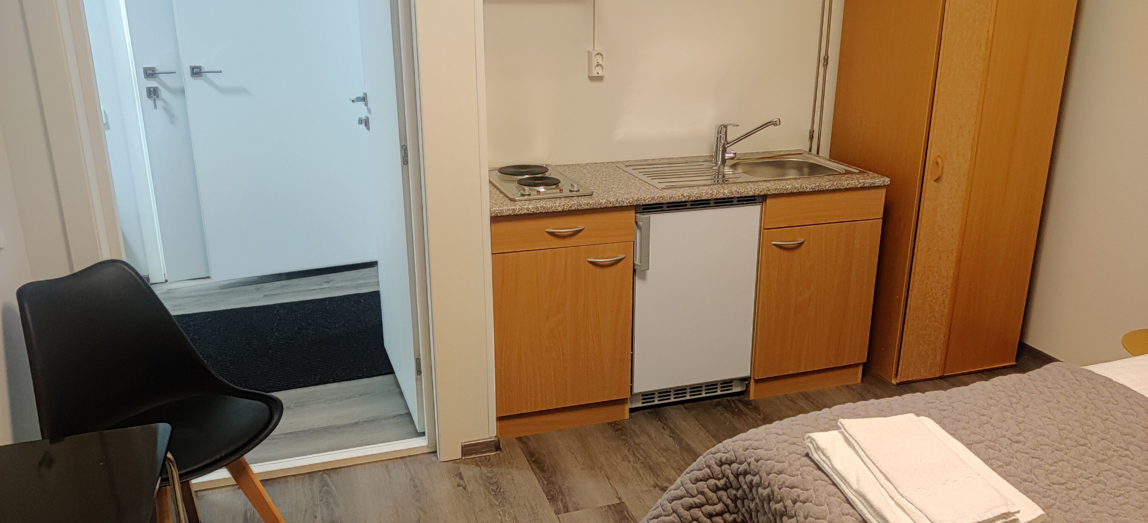 Una cocina compacta con un lavabo, lavavajillas y armarios de madera.