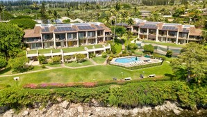 A resort with multiple buildings featuring solar panels, a swimming pool, and lush greenery. - Napili Point B33 1 Bedroom Oceanfront Condo 1 Condo by RedAwning (Lahaina)