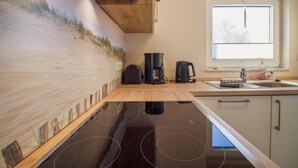 Cocina moderna con una isla grande, electrodomésticos integrados y un ventanal que proporciona luz natural.