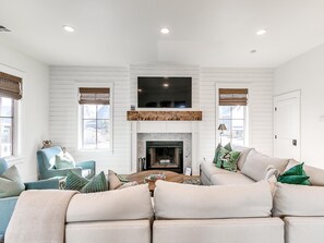 A living room with a fireplace, a television mounted above it, and a sectional sofa.