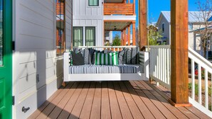 Eine Holzterrasse mit integrierter Bank und weißem Geländer.