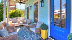 A porch with wicker furniture, a blue door, and a ceiling fan. - Carlton Landing-True Blue (Carlton Landing)