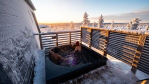 A snow-covered outdoor hot tub area with a view of a snowy landscape and trees. - Aurora Collection Saariselkä (Saariselka)