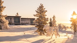 A snow-covered landscape with a building featuring large windows and a flat roof. - Aurora Collection Saariselkä (Saariselka)