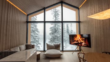 Un intérieur moderne avec une grande fenêtre, une cheminée, un canapé et un coin repas.