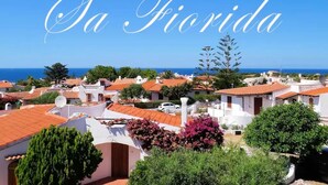 A coastal town with white buildings and red roofs, and the text "Sa Florida" prominently displayed.