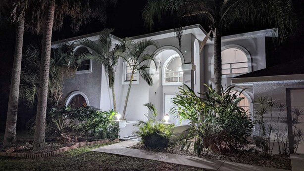 A two-story building with arched windows and a central courtyard. - Villa Camellia 5bed/4.5 bath with private pool and golf course view (Lehigh Acres)