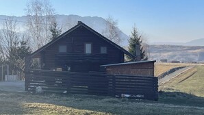 A rustic wooden cabin with a sloped roof, surrounded by a wooden fence and a small shed. - Stunning 4-bed Chalet in Bran With Superb Panorama (Bran)