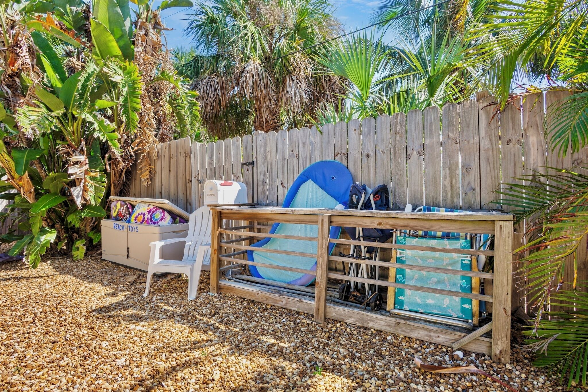A wooden playpen with a blue slide and a white chair.