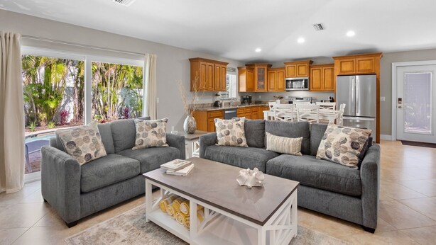 A modern living room with two grey sofas, a coffee table, and a ceiling fan.