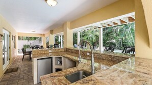 A kitchen with a granite countertop, stainless steel sink, and a built-in dishwasher. - Poseidons Palace! Family Fun and Gulf Views! (Holmes Beach)