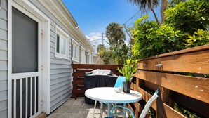 A patio with a white table, blue chairs, and a small potted plant. - Beach Home with Pool Access and Private Patio with BBQ Grill! - Little Dream (Holmes Beach)