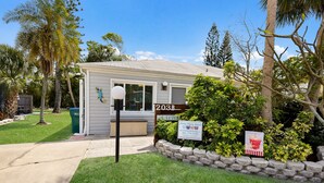 A single-story house with a mailbox, a mailbox stand, and a sign indicating it is for sale. - Beach Home with Pool Access and Private Patio with BBQ Grill! - Little Dream (Holmes Beach)