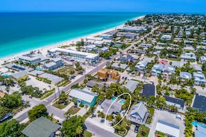 An aerial view of a coastal town with a beach, residential buildings, and a highlighted property with a swimming pool. - Home with Private Backyard and Heated Pool - Gulf Breeze Villa B (Holmes Beach)