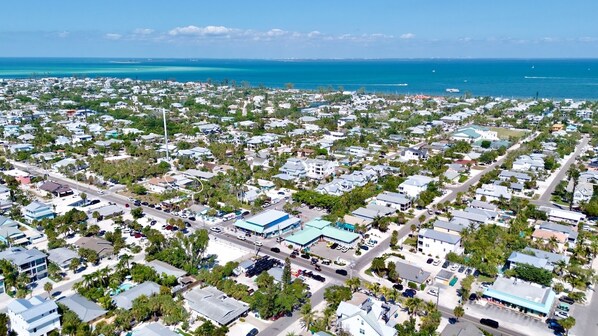 An aerial view of a coastal residential area with houses, roads, and a clear view of the ocean. - Private, Remodeled Home with Pool! 1 Block to Beach, Great for Families! (Anna Maria)