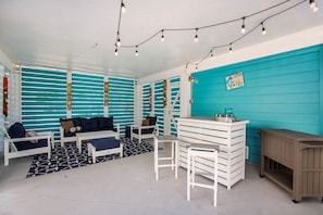 Ein Zimmer mit türkisfarbenen Wänden, weißen Möbeln und Lichterketten.