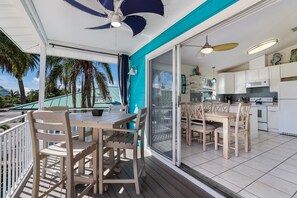 A modern kitchen with white cabinets, a microwave, and a tiled backsplash. - Private Home 1 Block to Beach with Pool and Hot Tub! (Anna Maria)