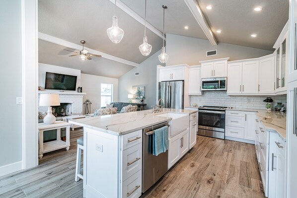 Enjoy cooking in this well-equipped kitchen with a large island, oven, and stainless steel refrigerator.