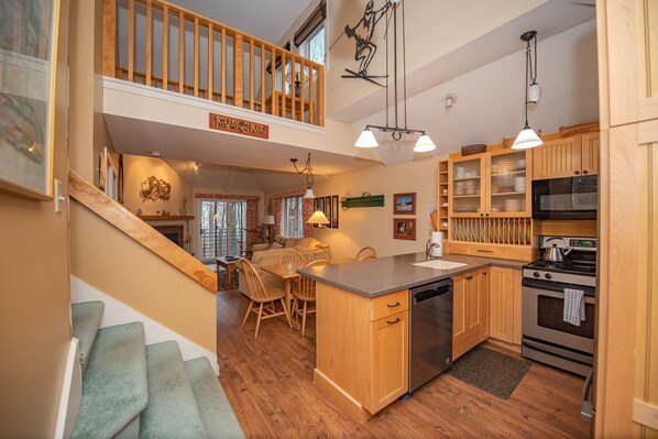 A kitchen with wooden cabinets, a stainless steel dishwasher, and a stove.