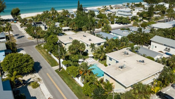 Vista aérea de una zona residencial costera con casas, una carretera y una playa.