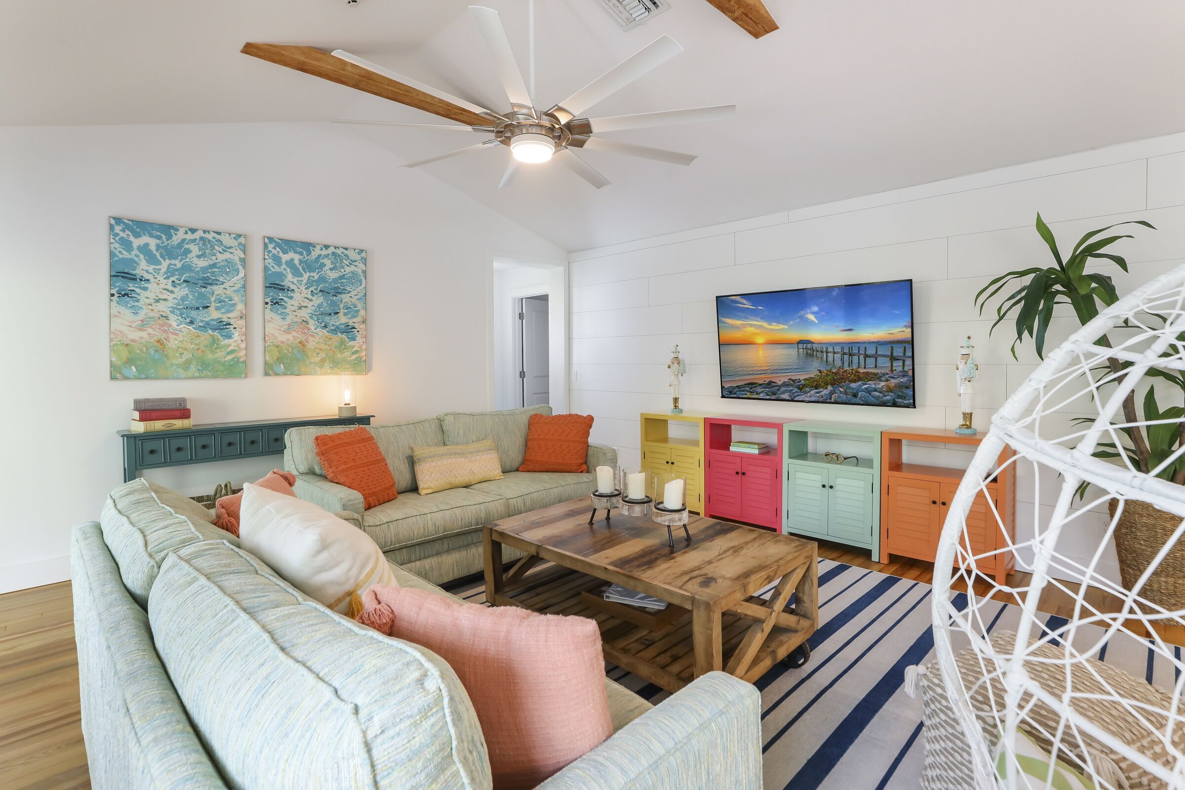 A modern living room with a sectional sofa, a wooden coffee table, and a ceiling fan.
