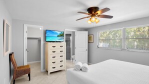 A bedroom with a bed, a television, a ceiling fan, and a wardrobe. - Island Mojo! Family-Friendly Beach Escape! (Holmes Beach)