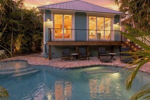 A house with a pool, a covered deck, and a staircase leading to the upper level. - Enjoy Endless Fun with a Private Heated Pool at Key Largo Cottage! (Holmes Beach)