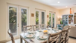 A dining area with a table set for four, surrounded by wooden chairs. - It's a Jungle Out There - Tropical Pool, Sunset Views, Game Room! (Holmes Beach)