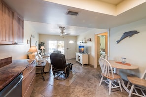 A kitchen with a dining area, a ceiling fan, and a dolphin wall decoration.