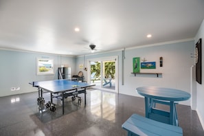 Relax in a spacious room with a ping pong table, framed artworks, and a dartboard.