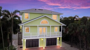 Une maison à deux étages avec un balcon, un garage et une allée.