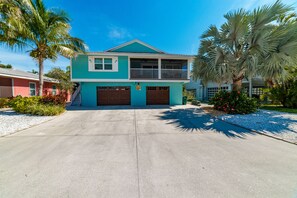 Une maison à deux étages avec un balcon, un garage et une allée.