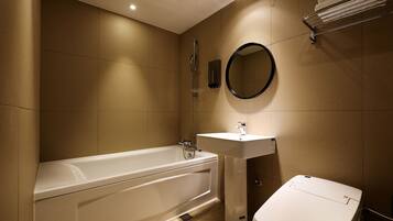A modern bathroom with a bathtub, a sink, and a toilet.