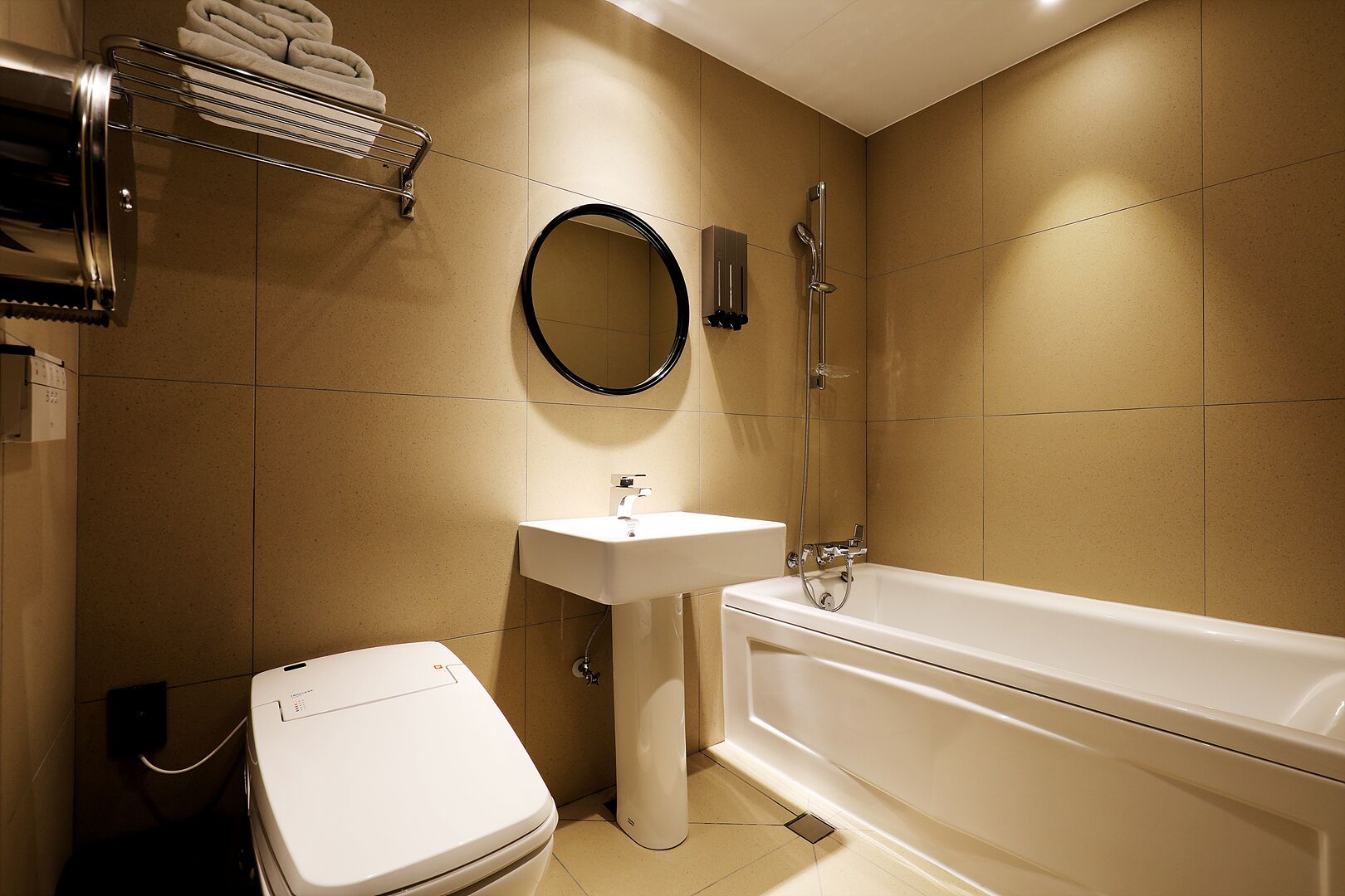 Une salle de bain moderne équipée de toilettes, d’un lavabo et d’une baignoire.