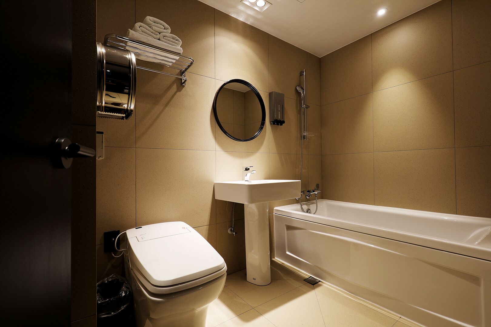 A modern bathroom with a toilet, sink, and bathtub.