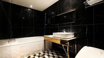 Un baño moderno con una bañera, un lavabo y un inodoro.