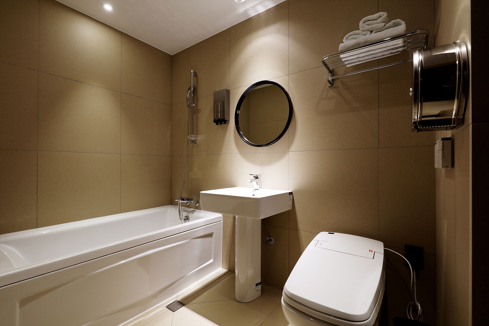 A modern bathroom with a bathtub, sink, and toilet.