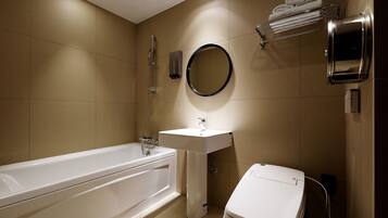 A modern bathroom with a bathtub, sink, and toilet.