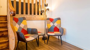 A staircase with wooden railings and a modern chair with a geometric pattern. - Spacious 3 Bedroom Apartment Online Check-In (Berlin)