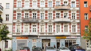 Een meerlaags gebouw met een rij balkons en een begane grond ingang.