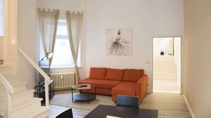 A living room with a sectional sofa, a coffee table, and a painting on the wall.