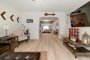 A modern living room with a sofa, coffee table, and a TV stand. - Nice East Side 3BR 2BA WIFI SMART TV (Wichita)