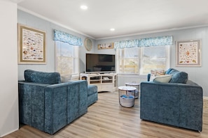 Relax in this stylish living room with two sofas, a flat-screen TV, and framed artwork.