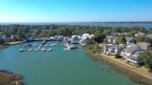 A marina with docked boats, waterfront houses, and a clear view of the water.